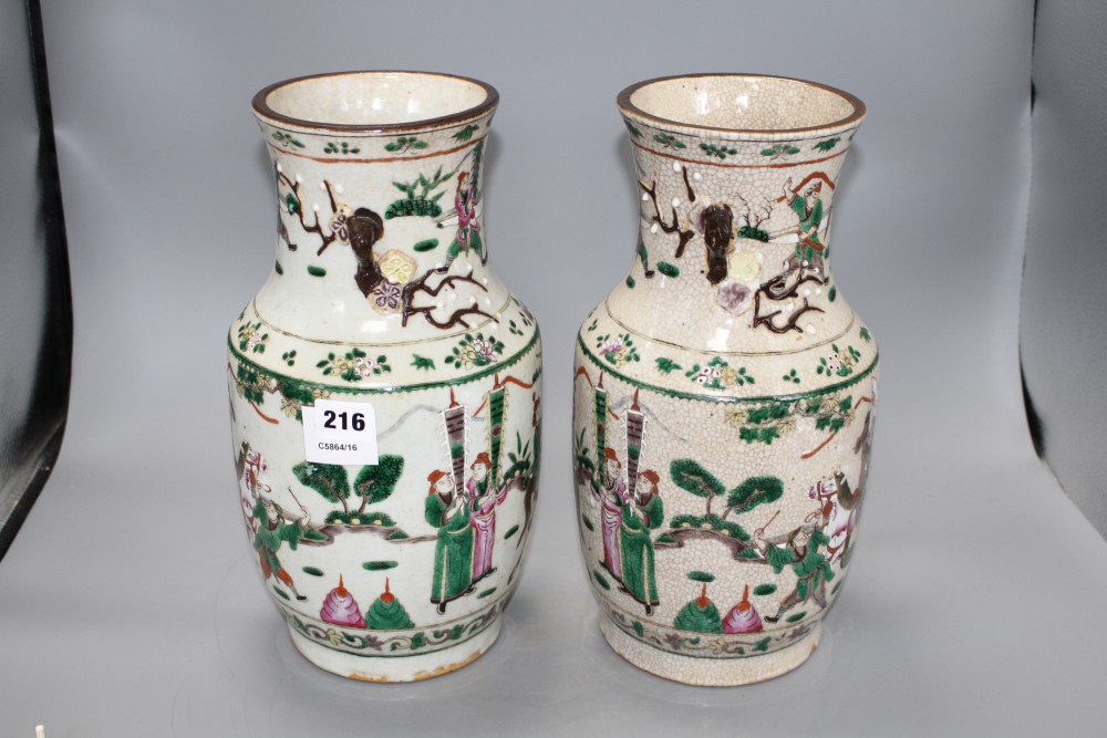 A pair of Chinese crackleware vases, decorated with figures in continuous landscapes, height 33cm